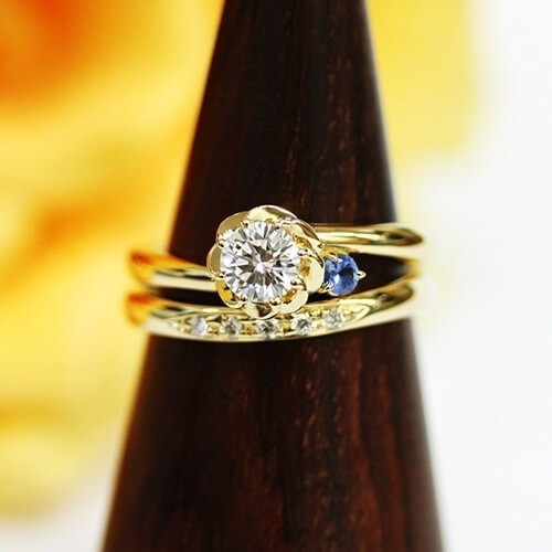 フラワーデザインの婚約指輪とシンプルなラインにダイヤモンドを入れた結婚指輪をセットリングにしました。合わせて着けるととてもゴージャスながらも可憐な指輪です。